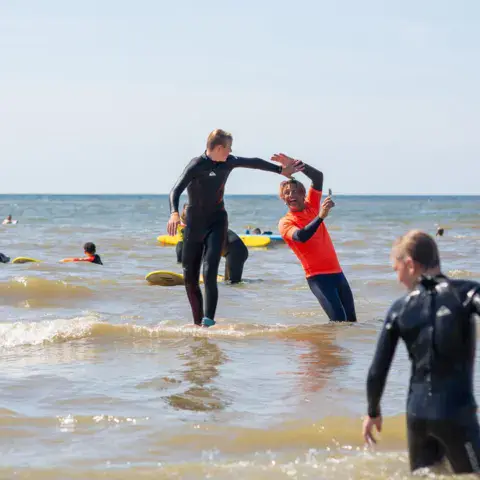 Cours de surf dans l'eau avec un moniteur