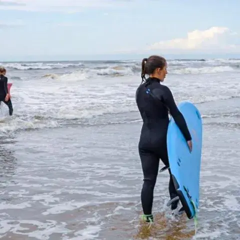 Surfeurs avec leurs planches au bord de l'eau