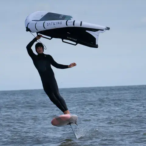 Wingfoileur en train de voler au-dessus de l'eau