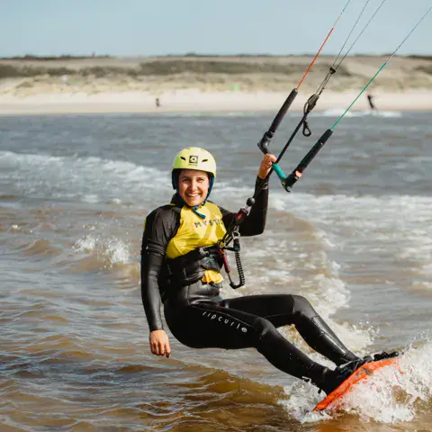 Élève en cours de kitesurf avec casque et gilet