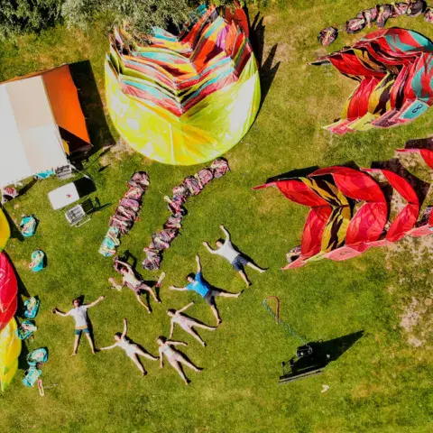 Vue aérienne d'un cours de kitesurf avec les kites étalés sur l'herbe