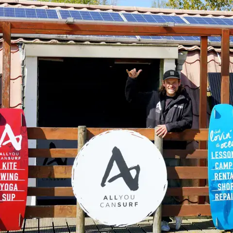 Boutique et point de location de la base, avec planches aux couleurs de l'école