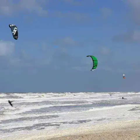 Plusieurs kites dans le ciel au-dessus de la plage