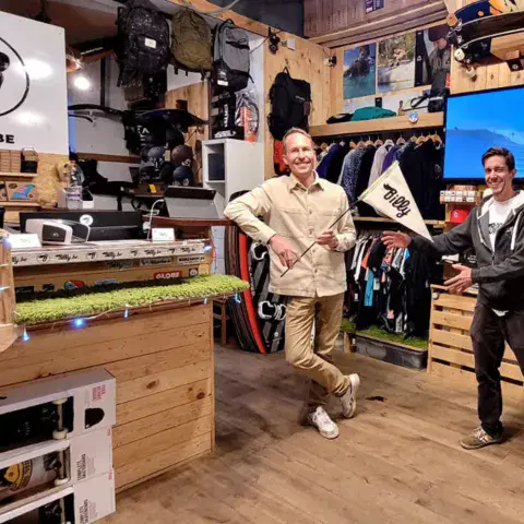 Intérieur du magasin : comptoir, planches et vêtements en rayon