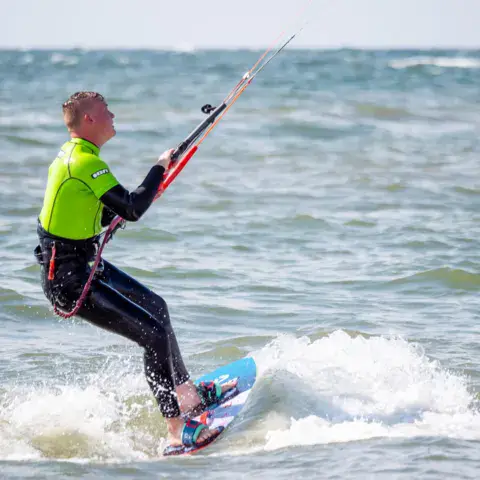 Élève de kitesurf en action sur l'eau