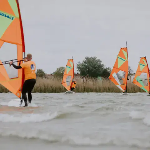 Groupe de planchistes à voile sur l'eau