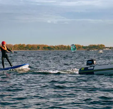 Rider sur le plan d'eau avec un bateau d'assistance