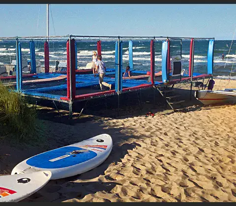 Trampoline et planches de paddle sur la plage