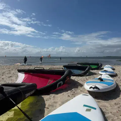 Ailes et planches de stand up paddle sur la plage