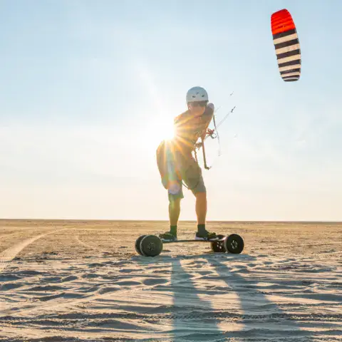 Landboard tiré par un kite sur la plage