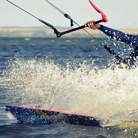 Kitesurfeur sur sa planche, avec gerbes d'eau
