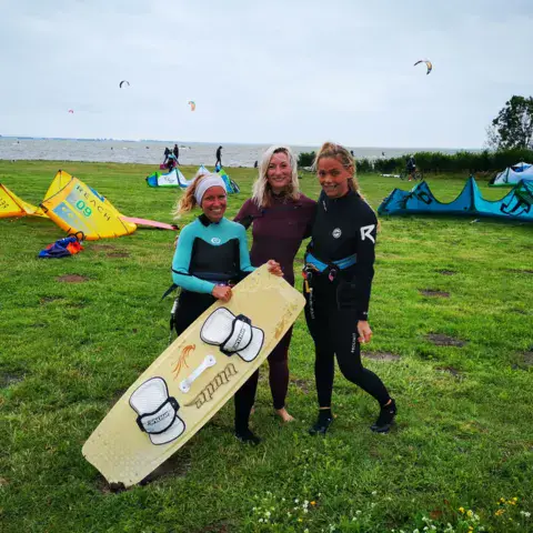 Élèves et kites étalés sur la pelouse du spot