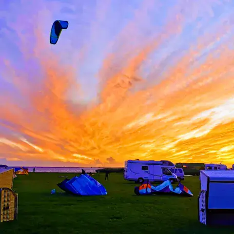 Station au coucher du soleil, avec kites et camping-cars