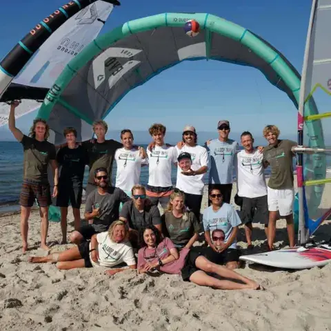 L'équipe de l'école sur la plage, avec un kite et une voile