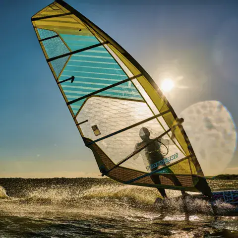 Windsurfeur à la voile, contre-jour