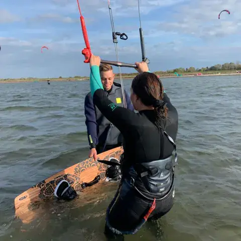 Un moniteur accompagne une élève dans l'eau