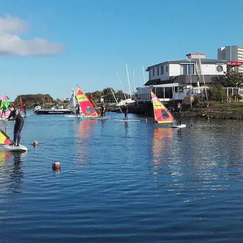 Planches à voile sur le plan d'eau devant la station