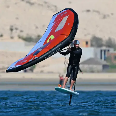 Wingfoiler en vol au-dessus de l'eau