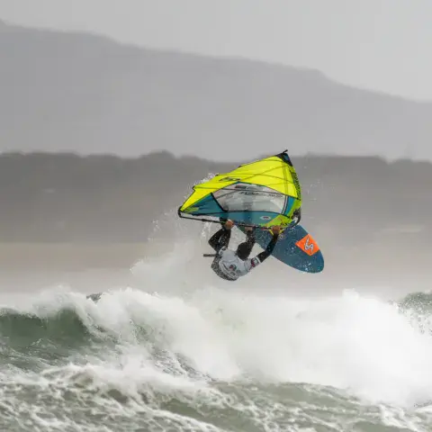 Windsurfeur en saut dans les vagues