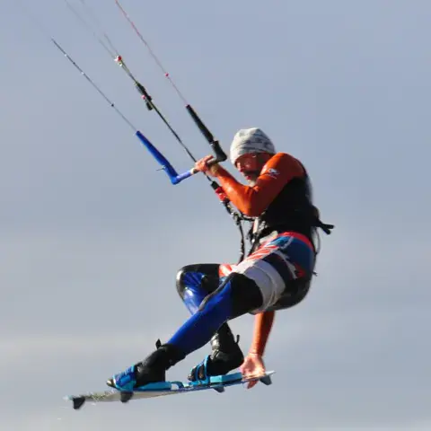Kitesurfeur en l'air, planche aux pieds