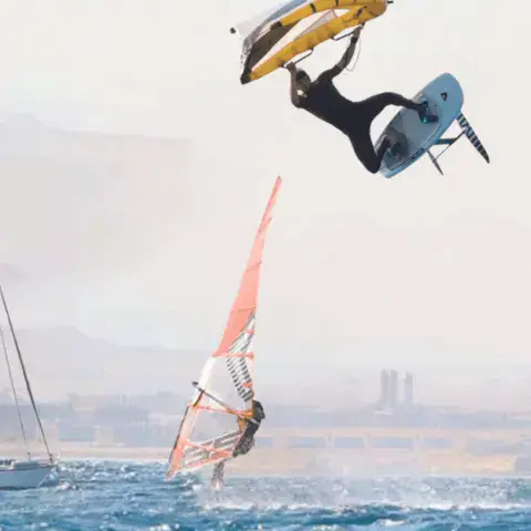 Windsurfeur en saut sur le plan d'eau