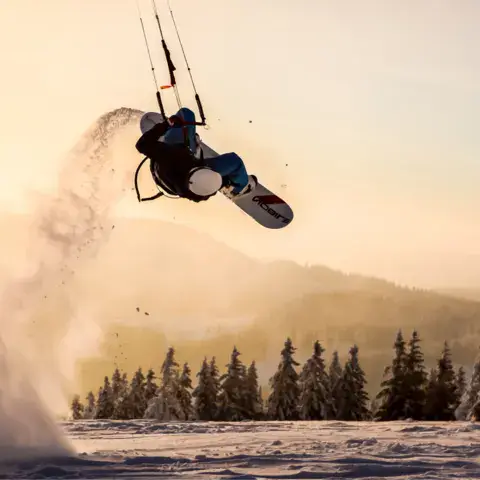 Saut en snowkite au coucher du soleil