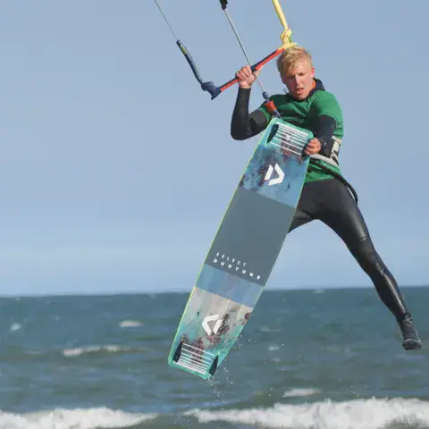 Kitesurfeur en saut avec sa planche