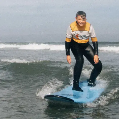 Jeune surfeur debout sur sa planche