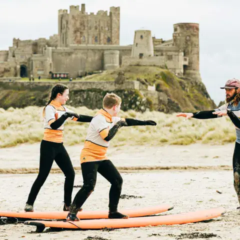 Exercice sur le sable avec le château de Bamburgh en arrière-plan