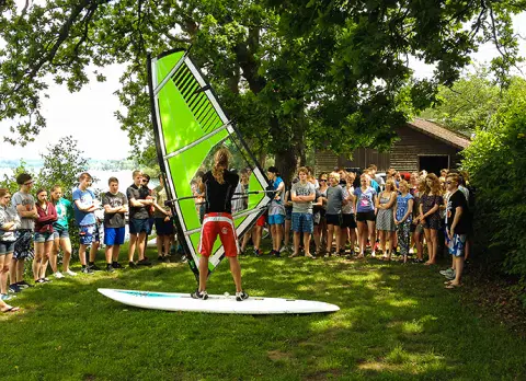 Une classe écoute une démonstration de windsurf sur la pelouse