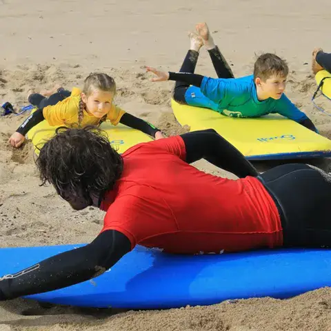 Exercice de rame à plat ventre sur le sable avec un moniteur