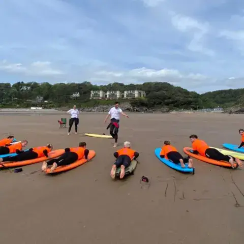 Séance d'initiation à terre sur la plage de Caswell Bay