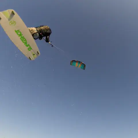 Kitesurfeur en l'air, planche en main