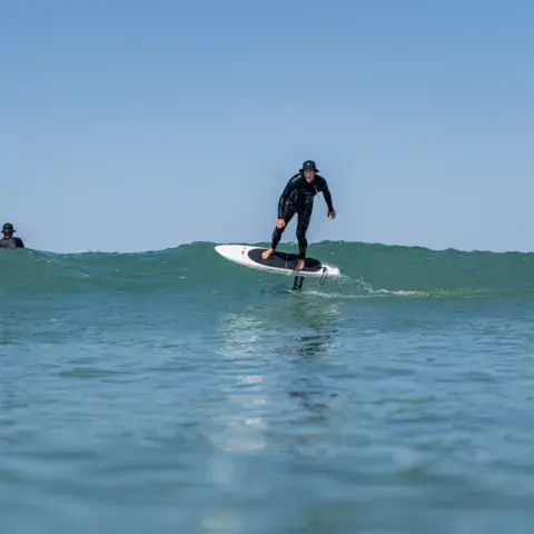 Surfeur sur foil dans une petite vague