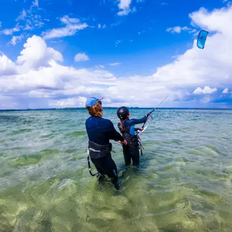 Moniteur et élève dans l'eau peu profonde