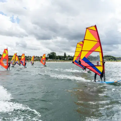 Groupe de windsurfeurs sur la baie