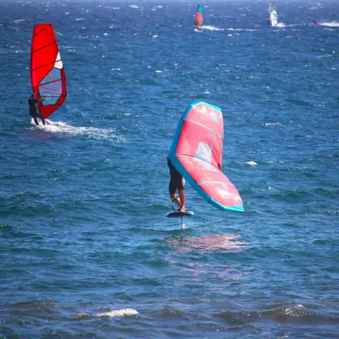 Windsurfeurs en foil sur l'eau