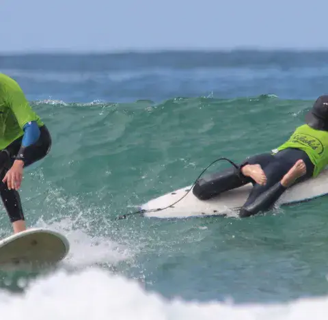 Deux élèves sur une vague pendant une leçon de surf