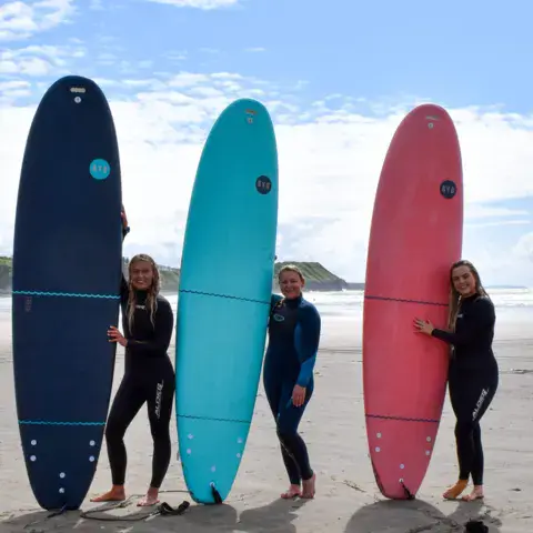 Planches de surf d'initiation dressées sur la plage