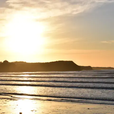 Coucher de soleil sur la plage et les vagues