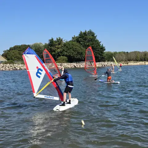 Débutants en windsurf sur l'eau calme
