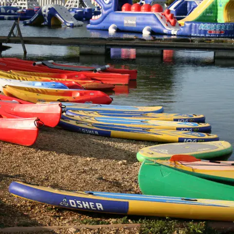Kayaks et paddles rangés sur la rive
