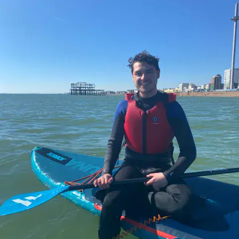 Pagayeur assis sur un paddle en mer