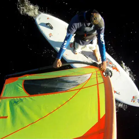 Un windsurfeur vu du dessus, debout sur sa planche