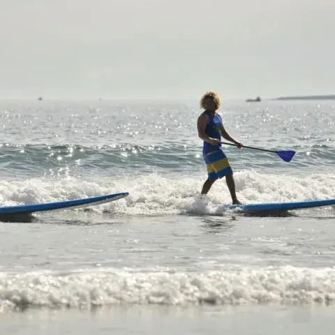 Deux pratiquants en stand up paddle dans les vagues