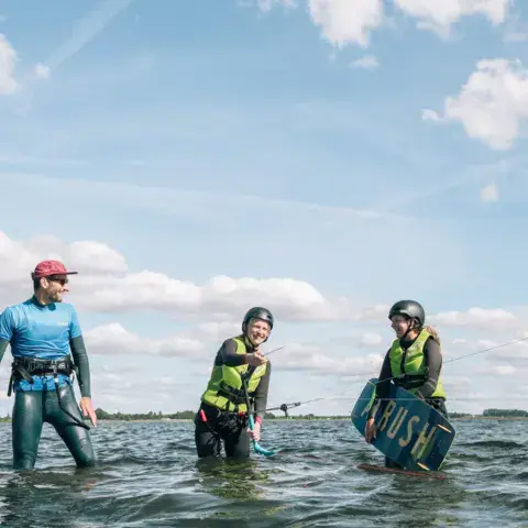 Moniteur et élèves dans l'eau peu profonde pendant un cours