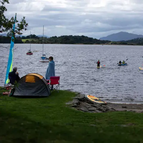 Voiles et paddles sur le loch depuis la rive