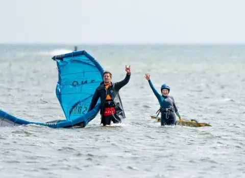 Deux élèves dans l'eau peu profonde avec une aile de kite