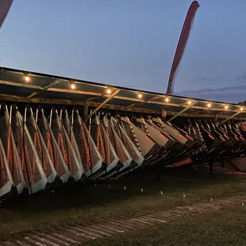 Matériel de windsurf rangé sous l'abri de la base, en soirée