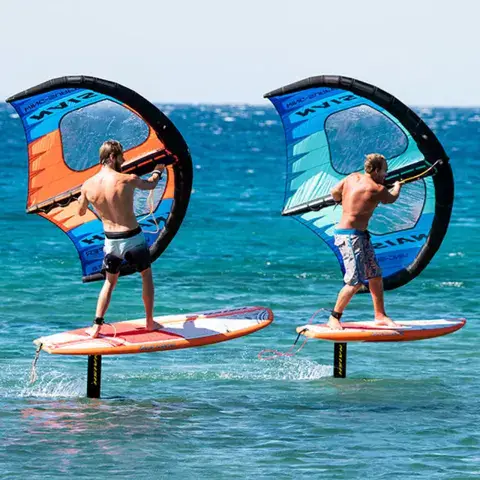Deux pratiquants de wing foil sur une eau turquoise